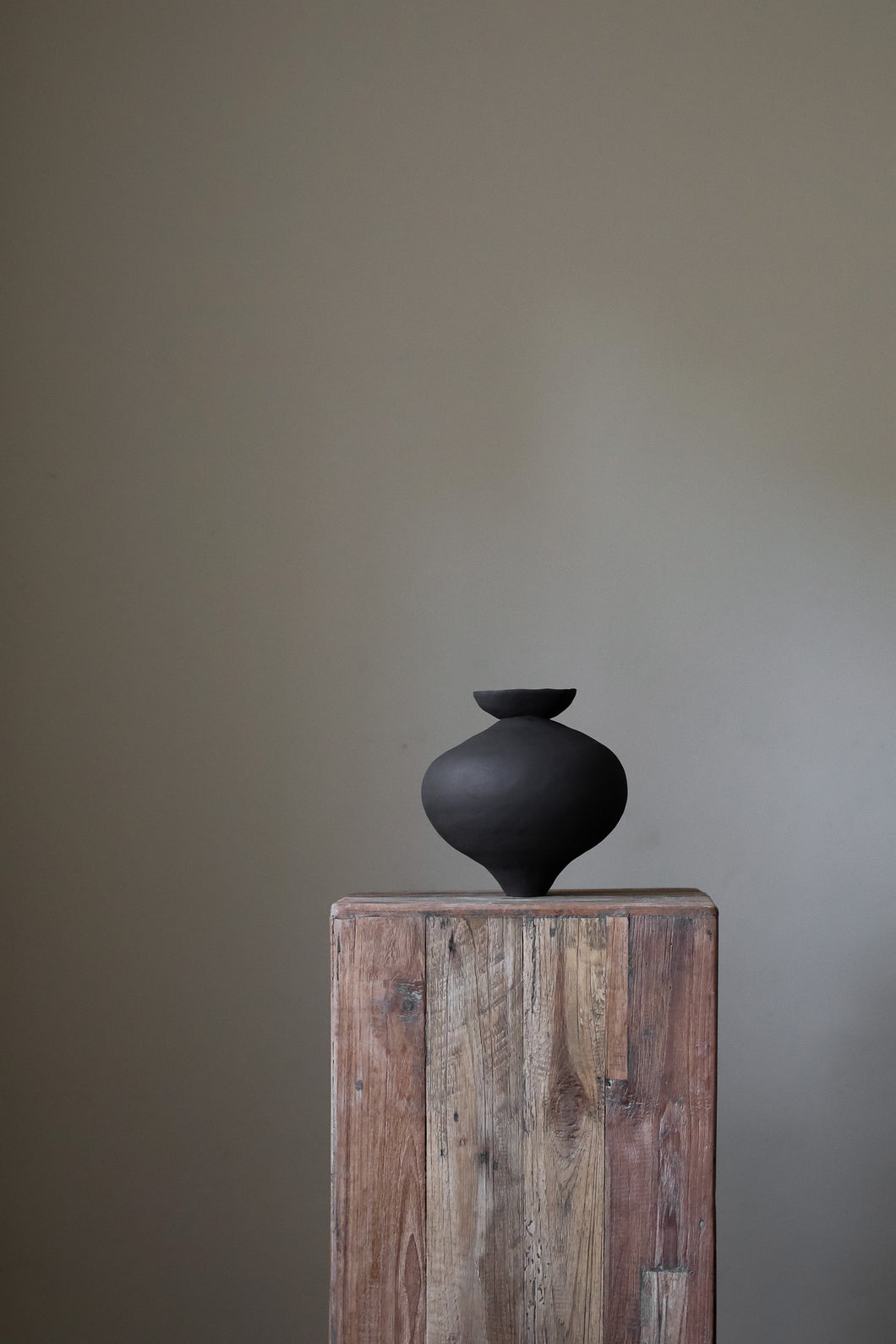 Unique sculptural vase with dish element by artist Hana, showcasing organic form and hand-built texture.