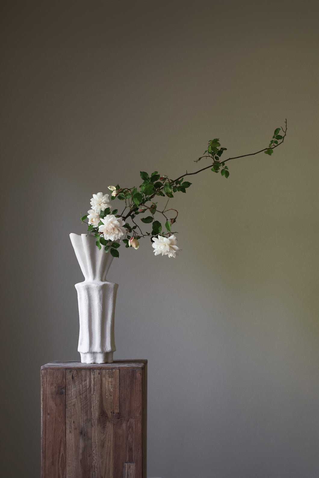 Hand-built white sculptural vase with a heavily textured, ribbed surface and a dramatically flared, fluted rim