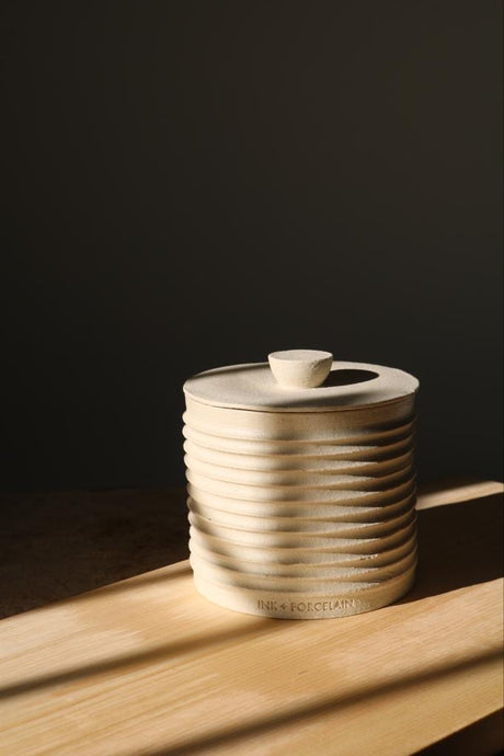 Elegant handmade lidded vessel in cream with raw texture and glazed interior, perfect for upscale interiors as a ring holder, coin keeper, or incense container.